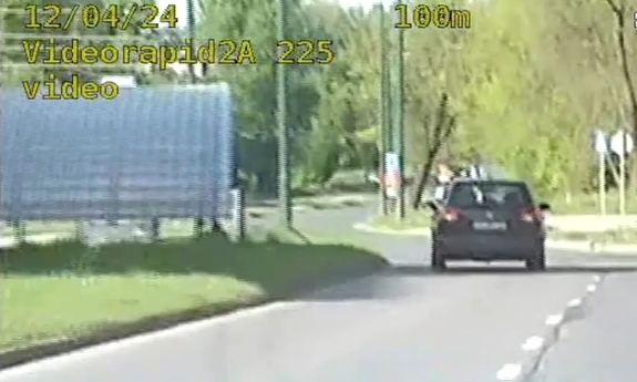 Stopklatka z nagrania wideorejestratora przedstawia samochód jadący po drodze